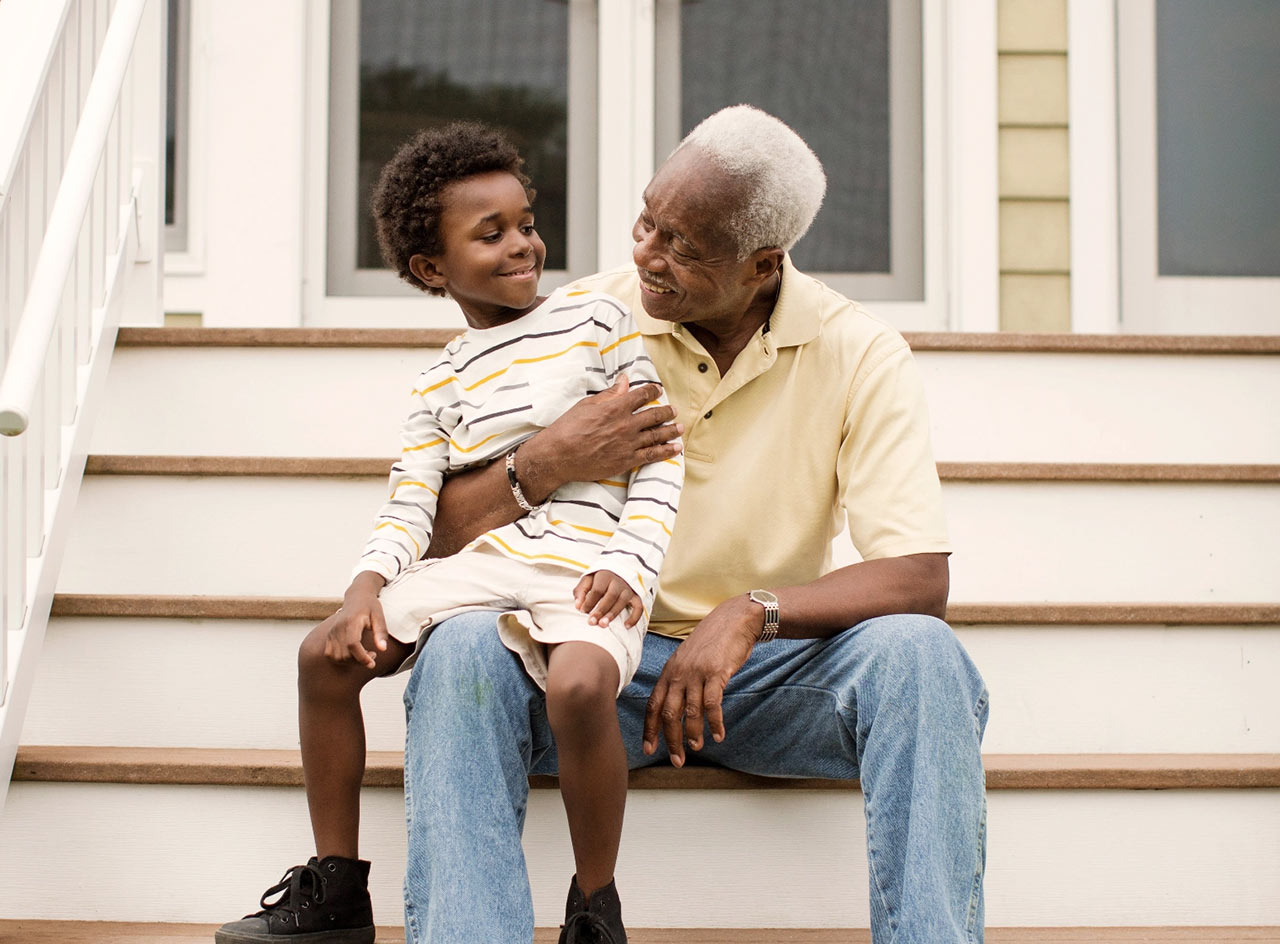 Smiling man and child sitting on stairs